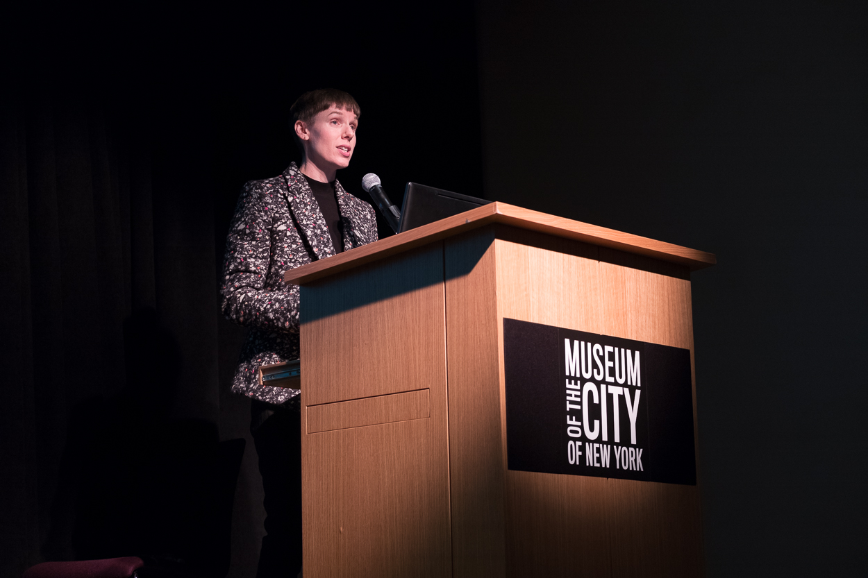 Sarah Seidman standing in front of a podium with black background